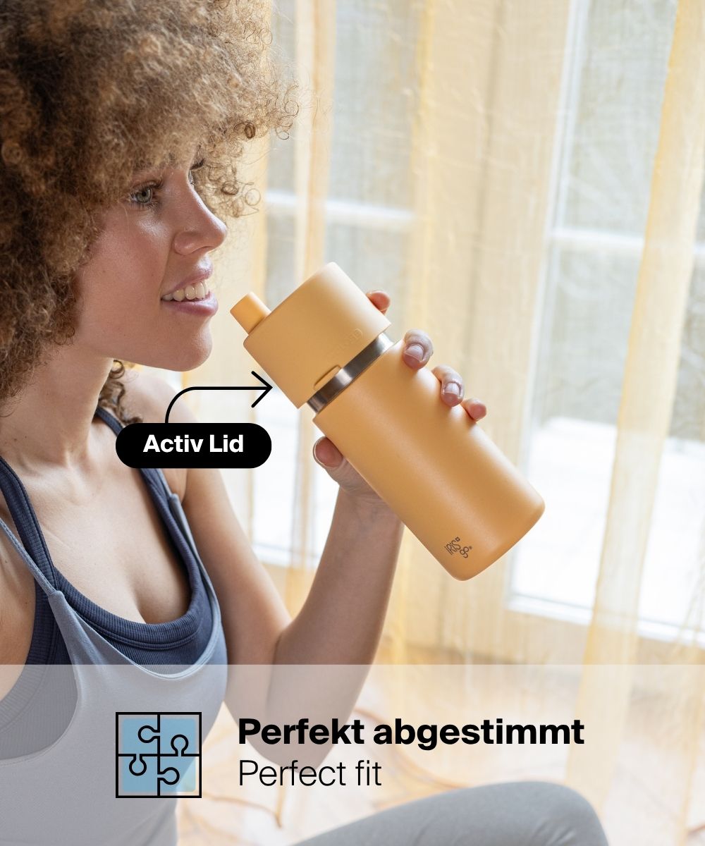 Frau trinkt aus dem IRISgo® cup flow 500ml Thermobecher in vibrant orange mit Active Lid, perfekt abgestimmte Flex Lids
