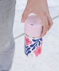 Hand hält IRISgo cup sip 350ml Boho Coral Design mit rush Lid unterwegs – auslaufsicherer Thermobecher to go