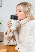 Frau trinkt aus IRISgo cup sip 350ml Floral Art Design – grosse Trinköffnung für vollen Kaffeegenuss