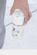 Hand hält IRISgo cup sip 350ml Floral Art Design mit rush Lid unterwegs – auslaufsicherer Thermobecher to go