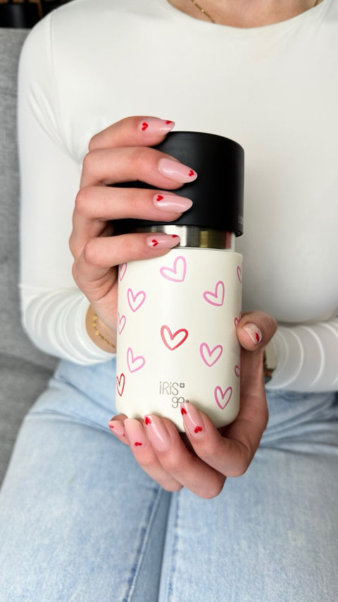 IRISgo Thermobecher mit Herz-Design in der Hand gehalten – stylischer, personalisierbarer Becher als Geschenkidee