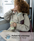 Frau im Mantel hält den IRISgo® cup sip 350ml Thermobecher in vanilla cream im Bus, perfekt für unterwegs