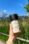 Hand hält IRISgo cup sip 350ml Swiss Design unterwegs – auslaufsicherer Thermobecher to go