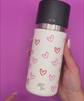 IRISgo cup flow 500ml im Herzdesign wird in der Hand rotiert.